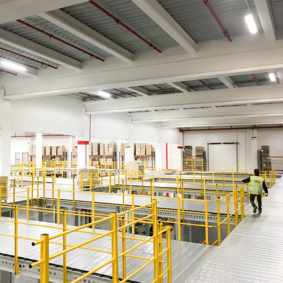 Ispezione periodica del magazzino industriale Tecnico durante il controllo di un soppalco e delle strutture di un magazzino industriale