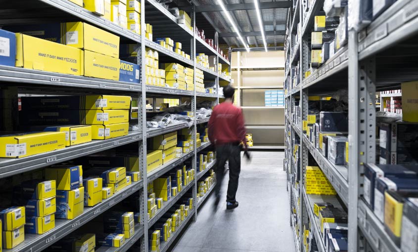 Operatore tra scaffalature industriali sottoposte ai controlli di sicurezza del PRSES